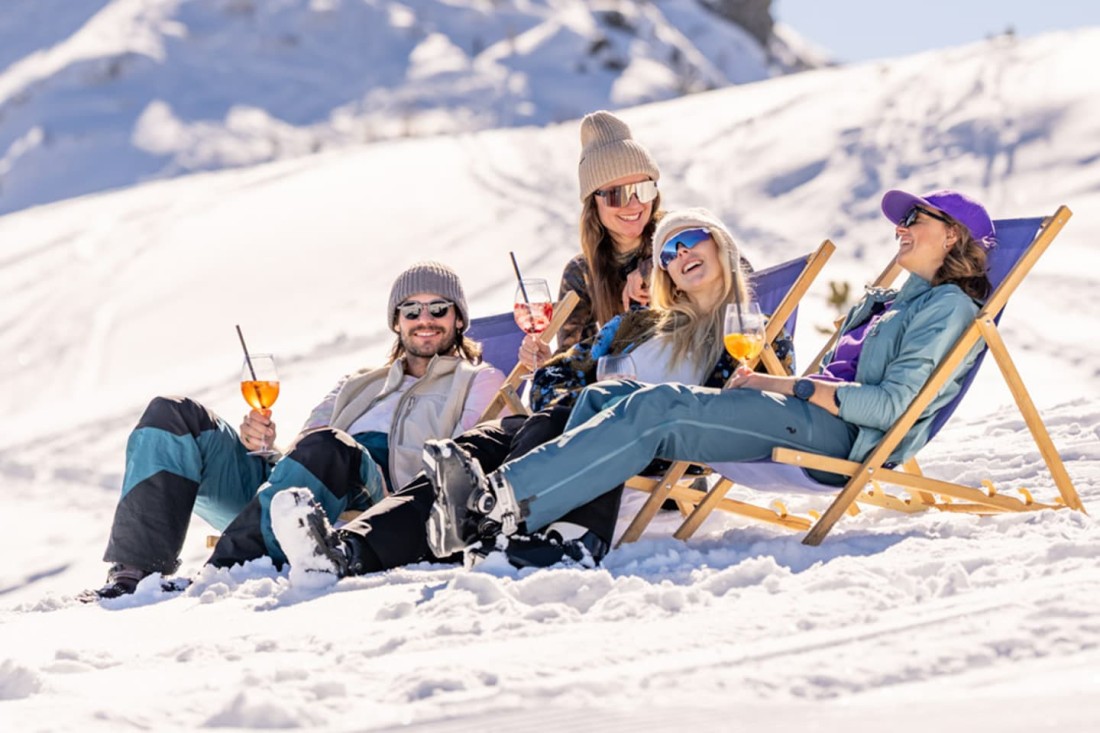 Mit Freunden relaxen im Liegestuhl abseits der Piste
